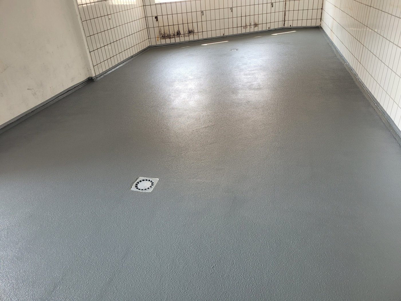 Grauer Werkstattboden mit Bodenablauf